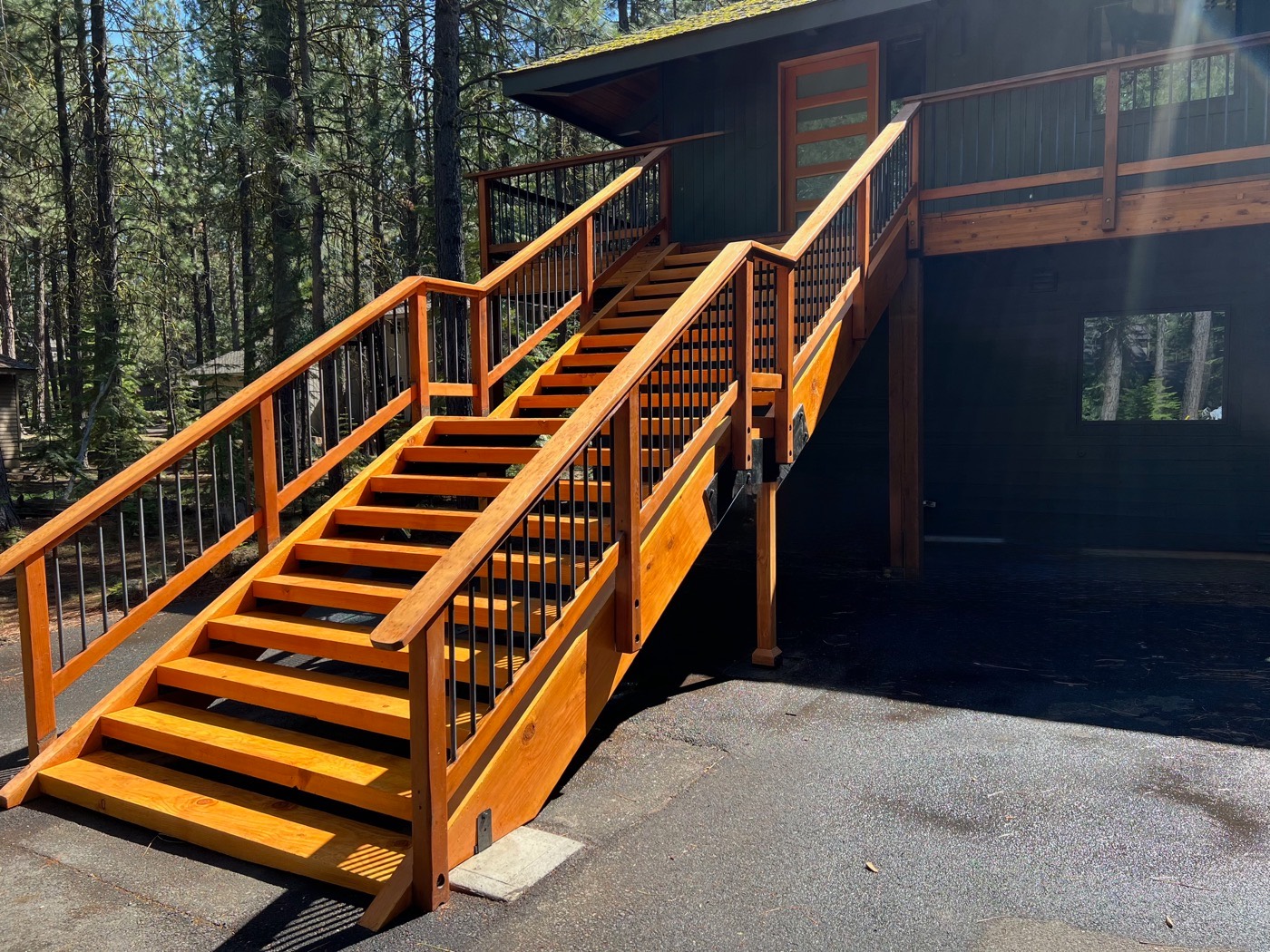 Wood exterior staircase with metal balusters rising to the front entry