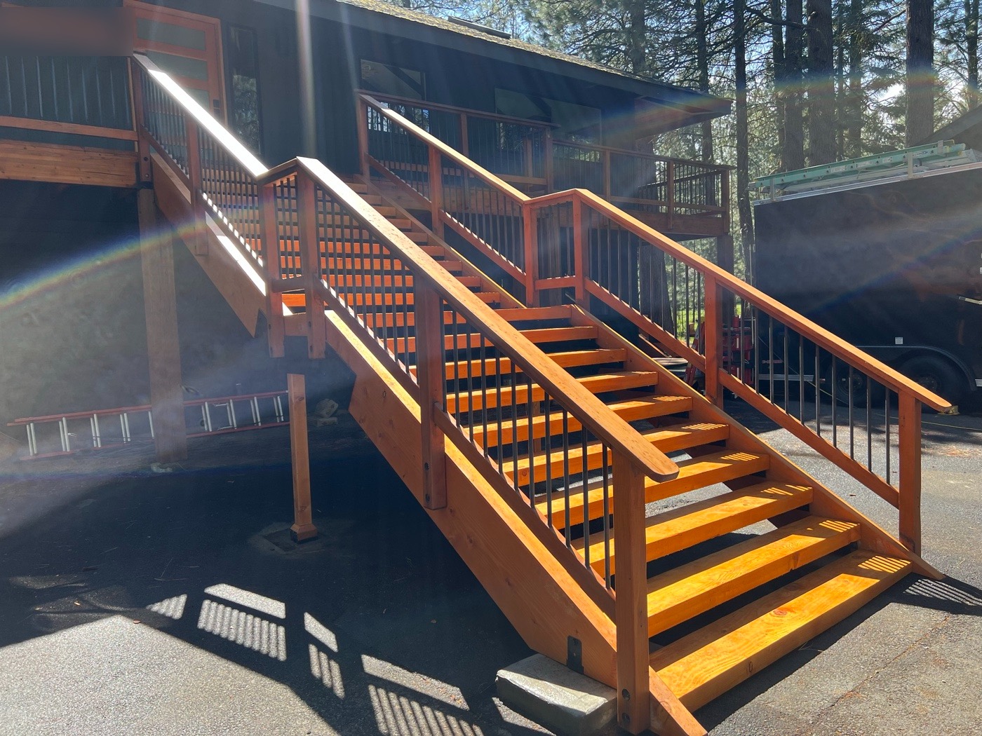 Open-riser wood treads and railings in afternoon sun